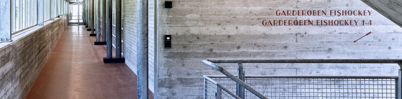 Innenansicht der Kunsteisbahn Ka-We-De mit Schriftzug Garderobe Eishockey auf Betonwand