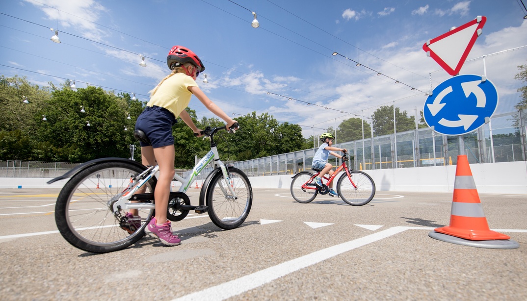 Zwei Kinder fahren Velo auf dem Verkehrspark im Weyerli