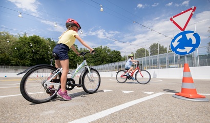 Zwei Kinder fahren Velo auf dem Verkehrspark im Weyerli