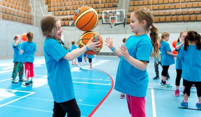 Zwei Mädchen in einer Turnhalle mit zwei Basketbällen