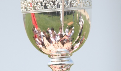 Hände eines Sportteams berühren einen Pokal