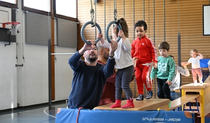 Kinder und Begleitperson beim Turnen an den Ringen