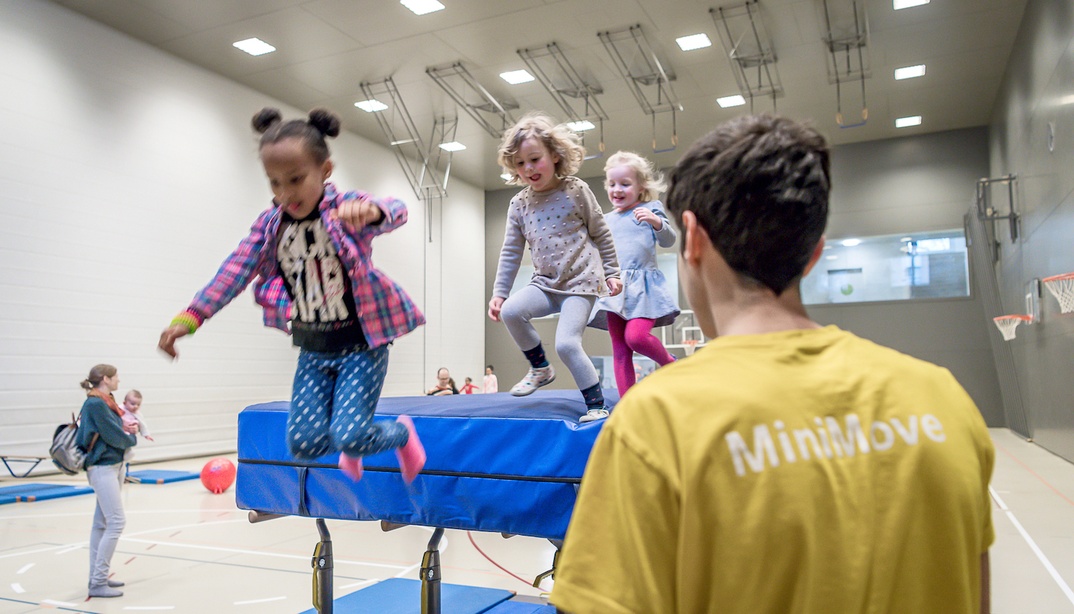 Kinder spielen in einer Turnhalle bei MiniMove