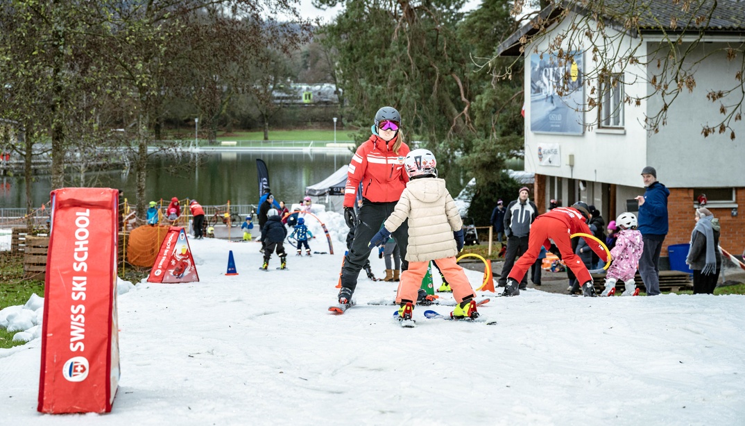 Skilehrerin und Kind auf Skierin fahren auf der Skipiste im Weyermannshaus