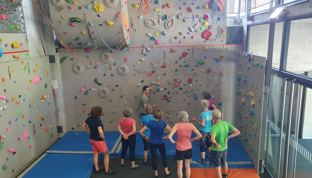 Senior*innen stehen vor einer Kletterwand in der AktivPlus Sportwoche