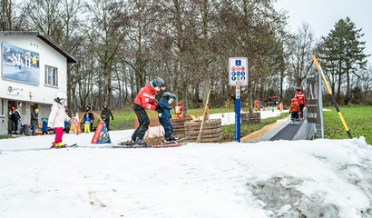 Kinder und Skilehrpersonen auf der Skipiste im Weyermannshaus