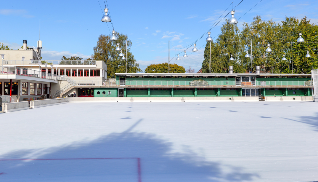 Leeres Eisfeld und Ansicht des Hauptgebäudes der Kunsteisbahn Ka-We-De